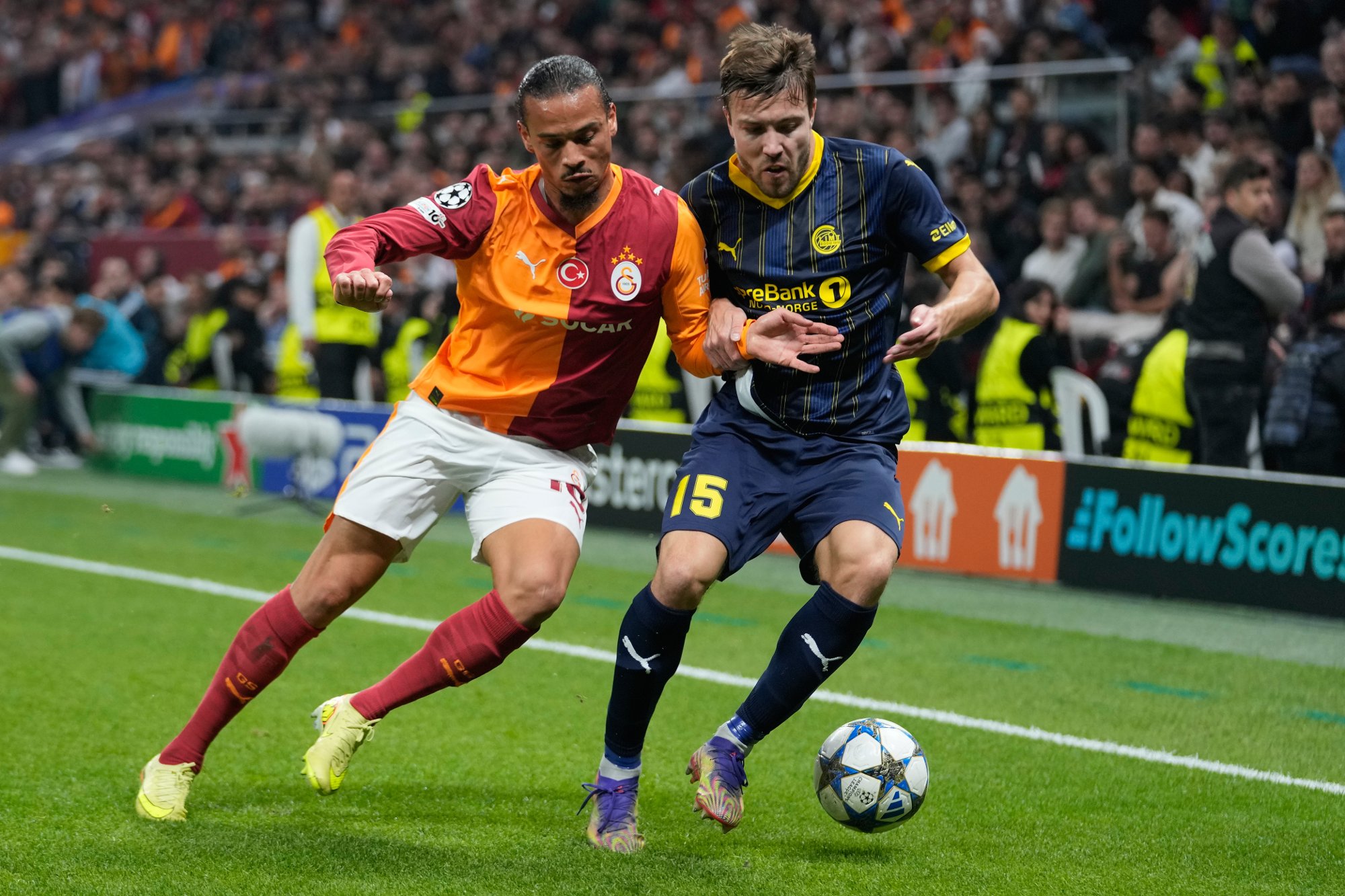 Galatasaray's Leroy Sane, left, duels for the ball with Glimt's Fredrik Andre Bjorkan during the Champions League opening phase soccer match between Galatasaray and Bodo Glimt, in Istanbul, Turkey, Wednesday, Oct. 22, 2025. (AP Photo/Khalil Hamra)