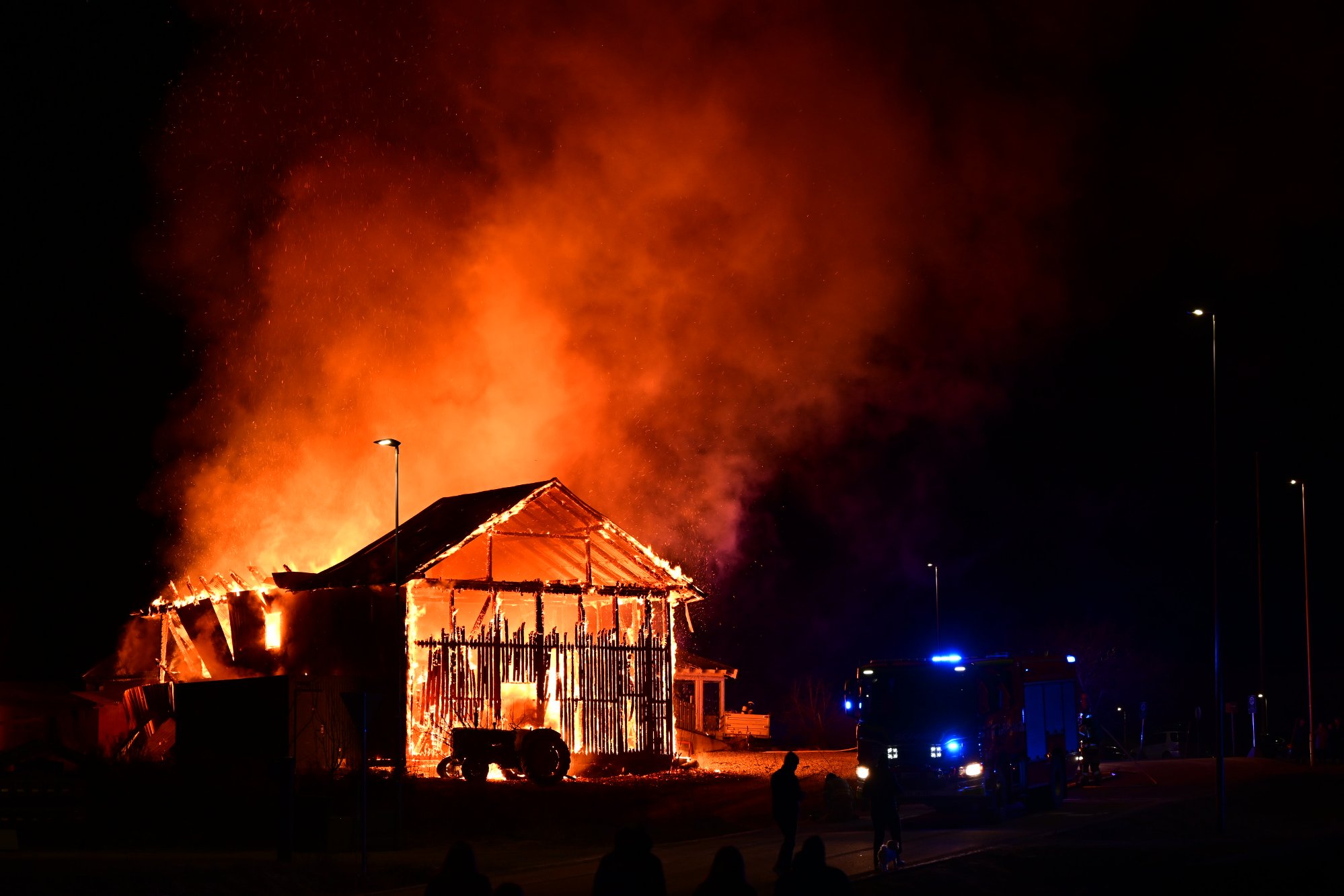 Kraftig låvebrann i Løten – brannfolk jobber for å redde bolighus